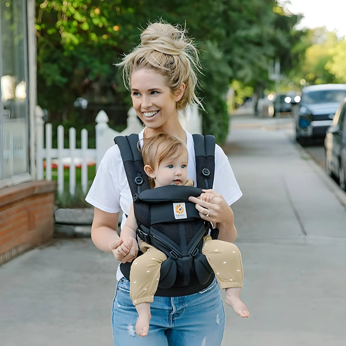 Mãe usando canguru ergonômico Ergobaby com bebê de frente em posição segura
