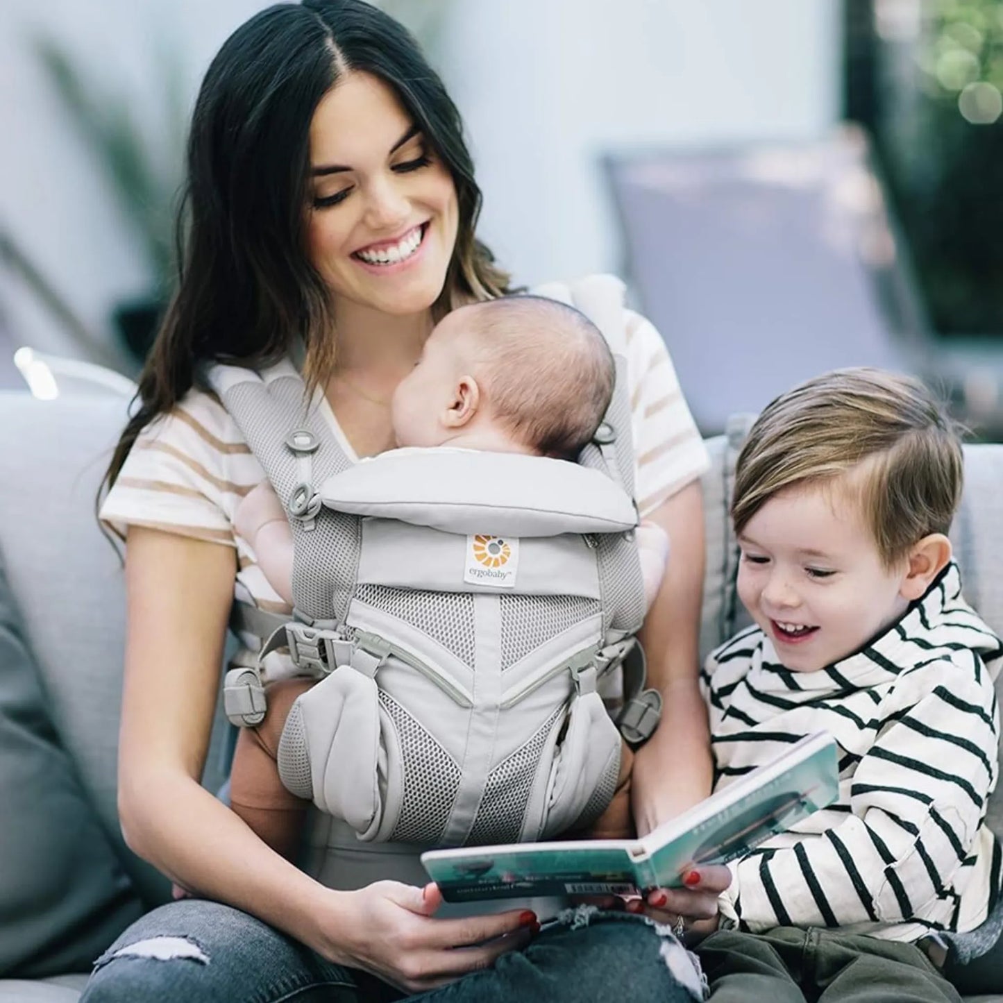 Mãe usando canguru ergonômico Ergobaby com bebê de frente em posição segura