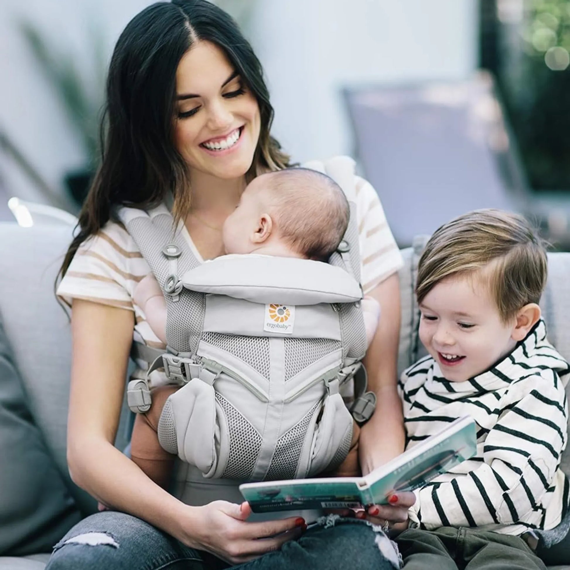 Mãe usando canguru ergonômico Ergobaby com bebê de frente em posição segura