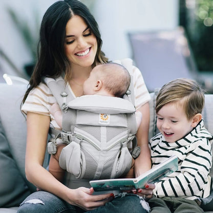 Mãe usando canguru ergonômico Ergobaby com bebê de frente em posição segura