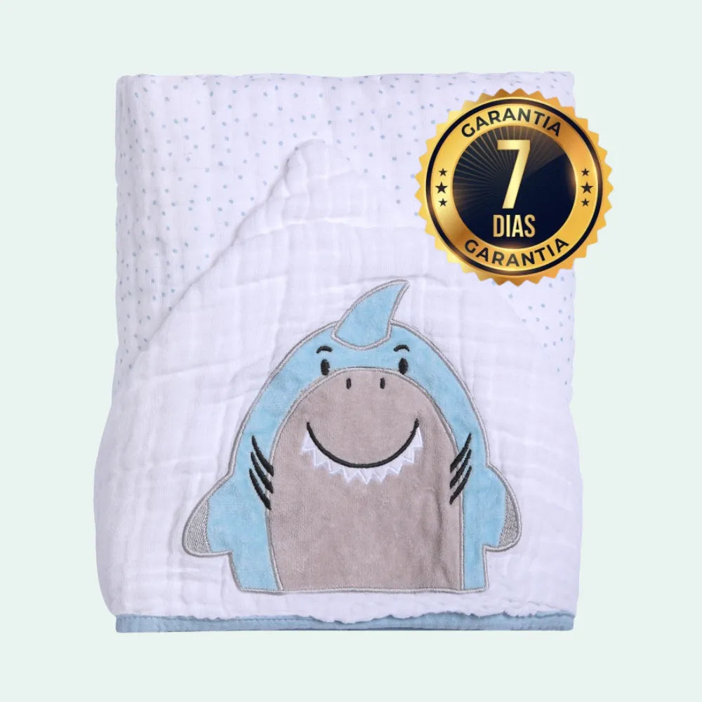 Detalhe de toalha de banho para bebes com bordado de tubarão azul e selo de 7 dias de garantia